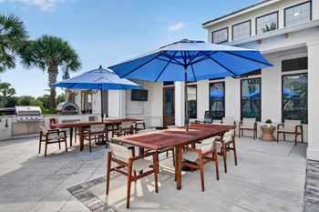 Custom pool area with fire pit lounge, grills, hot tub, and community tables